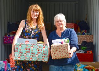 Who needs Santa? Amelia Lawley and Maggie Wikaira show off just some of the gifts that generous islanders have donated by the container-load. Photo Sophie Boladeras